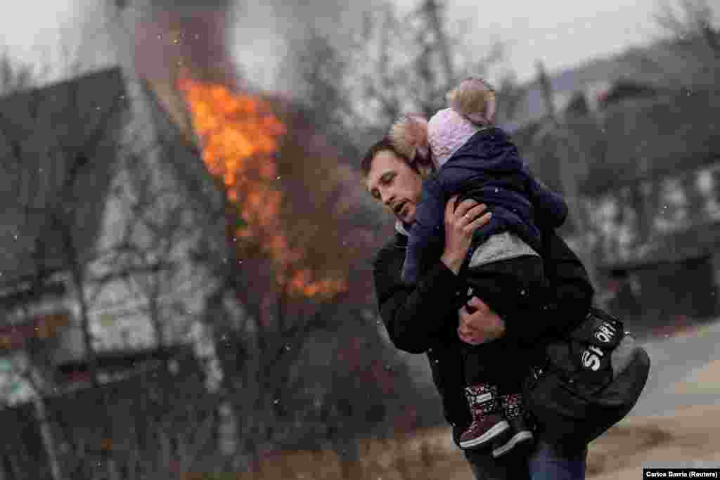 Ирпень қаласына шабуыл жасалғанда қашып бара жатқан ер адам мен бала. 6 наурыз 2022 жыл.