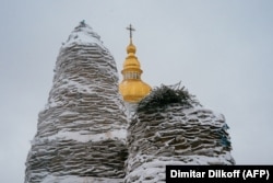 Памятники на Михайловской площади в Киеве, рядом с Михайловским Златоверхим собором, укрытые мешками с песком