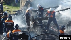 Russia -- Emergencies Ministry employees carry the burnt body of a victim from the debris of a psychiatric hospital destroyed by fire in the Novgorod region town of Luka, September 13, 2013