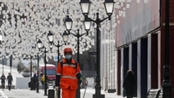 Дворник в защитной маске в Столешниковом переулке в Москве