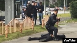 Убитый Артур Гаджиев с сидящим на нем полицейским