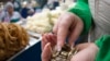 Kazakhstan -- A saleswoman at the dairy department counts coins at the Green Bazaar in Almaty January 23, 2015. 